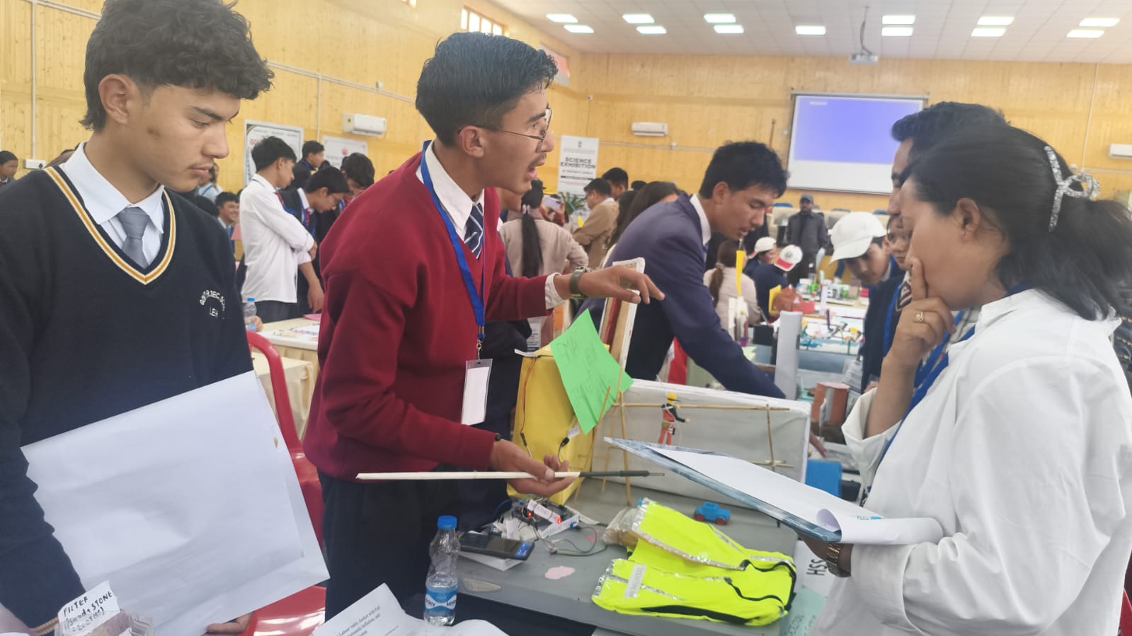 District Science Exhibition — Project Presentation GHSS Sakti students in uniform presenting a science project to a judge at the district science exhibition